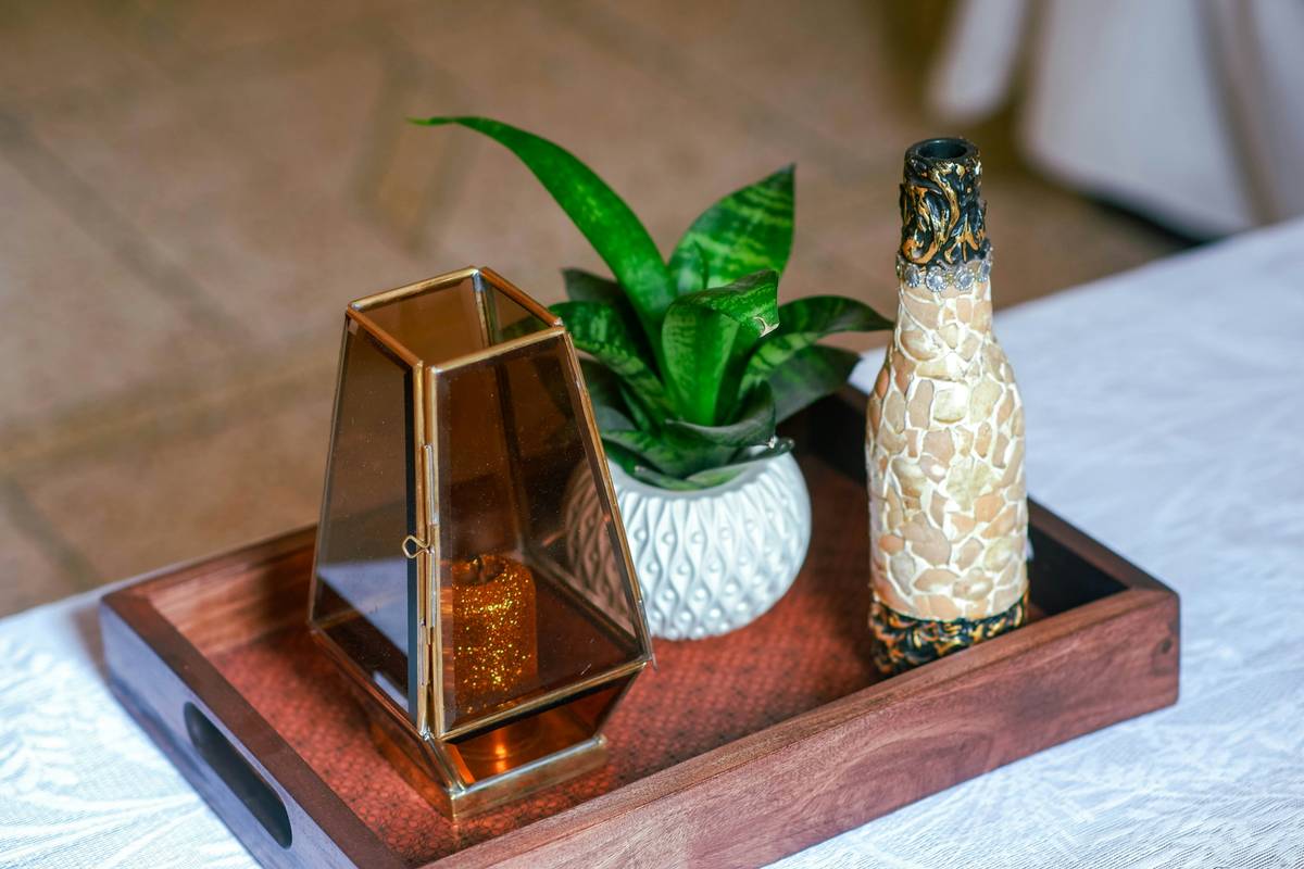 A rustic wooden tray featuring three pillar candles adorned with seasonal decorative rings for candles—dried citrus for fall, eucalyptus for spring, and velvet for winter