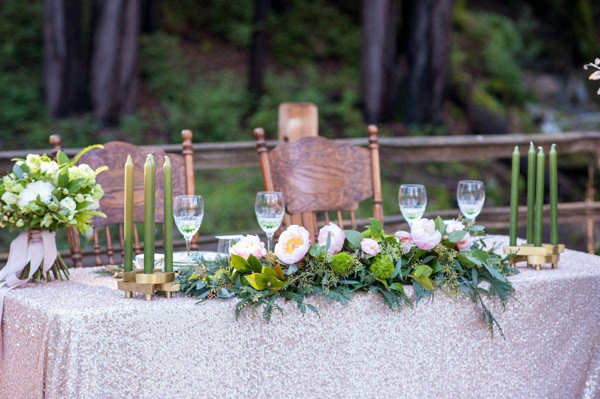 decorative floral rings for candles arranged around white pillar candles on a wooden table