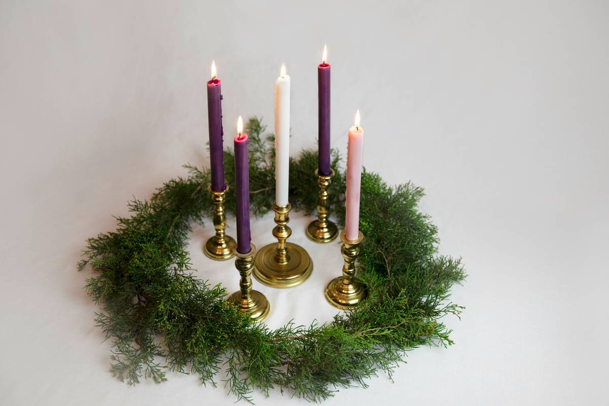 Stylish arrangement featuring decorative candles holland house surrounded by natural fiber candle rings on a rustic wooden shelf