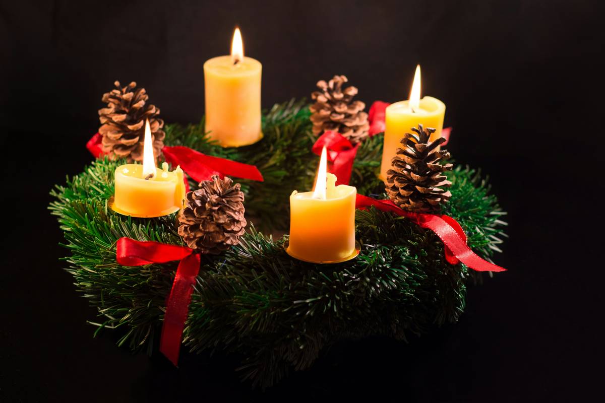 Christmas rings for candles on a rustic wooden dining table with pine sprigs and red berries